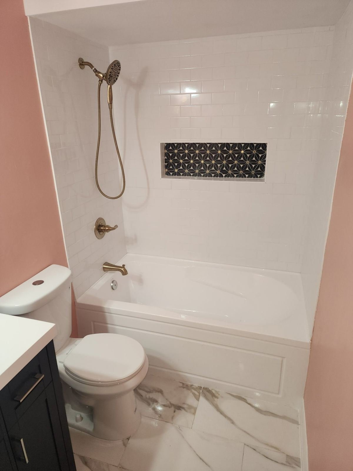 Completed bathroom remodel with subway tile gold fixtures and marble floor Southwest Florida